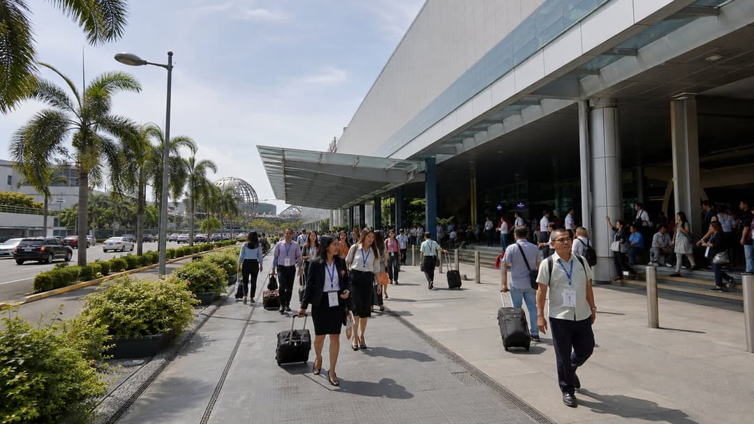 Business delegates arriving at a modern convention complex in Pasay