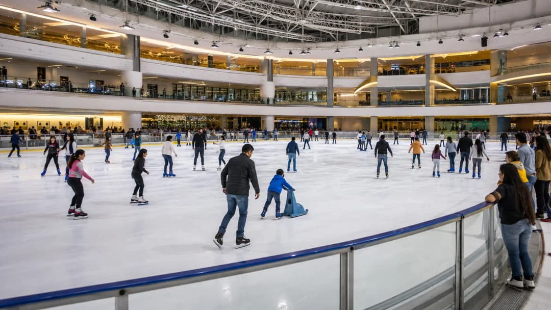 Families and beginner skaters on a bright indoor ice rink in Pasay