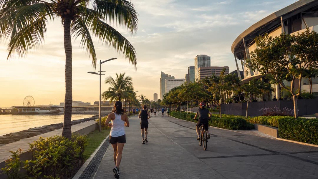 Joggers and walkers on a landscaped Bay City sidewalk at sunrise