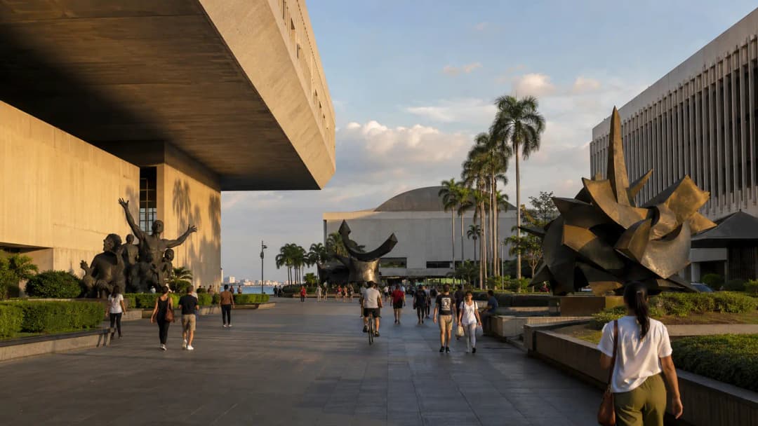Pedestrians and cyclists passing modernist arts buildings in the CCP Complex
