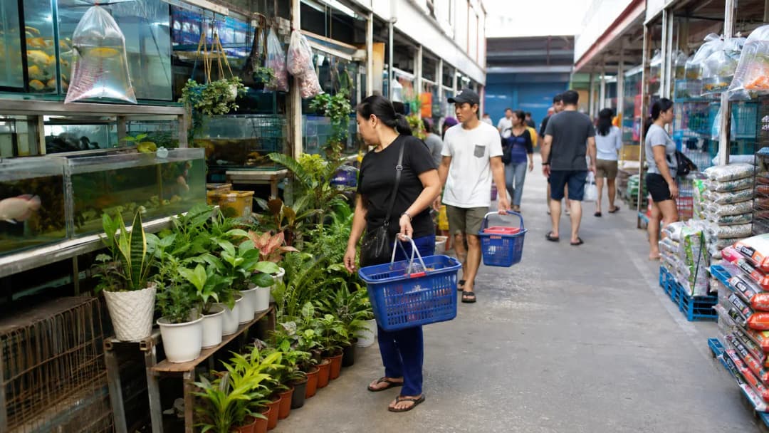 Shoppers browsing food, plants and aquarium supplies in a public Pasay market arcade