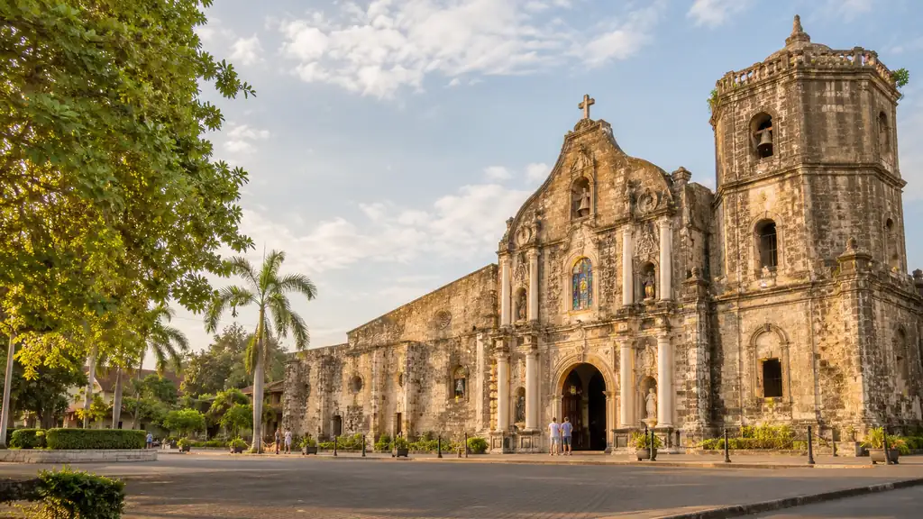 Historic stone church associated with the Las Pinas Bamboo Organ in warm tropical morning light