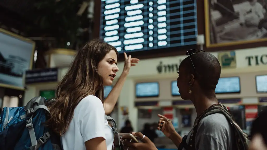 Travelers reviewing flight information in a Manila airport public area during rainy weather